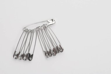 Giysiler için metal iğneler, beyaz arka planda izole edilmiş.