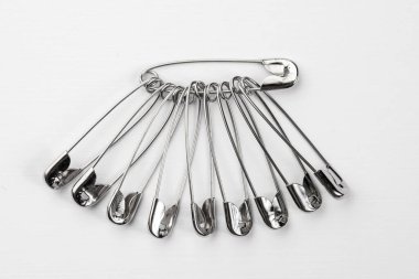 Giysiler için metal iğneler, beyaz arka planda izole edilmiş.