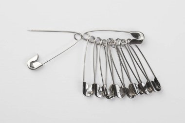 Giysiler için metal iğneler, beyaz arka planda izole edilmiş.