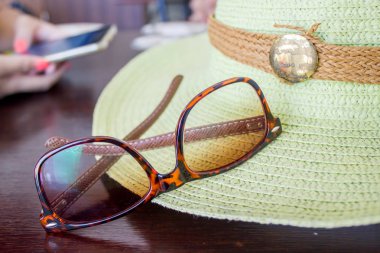 akıllı telefon kullanarak kız el ile güneş gözlüğü ve yeşil şapka