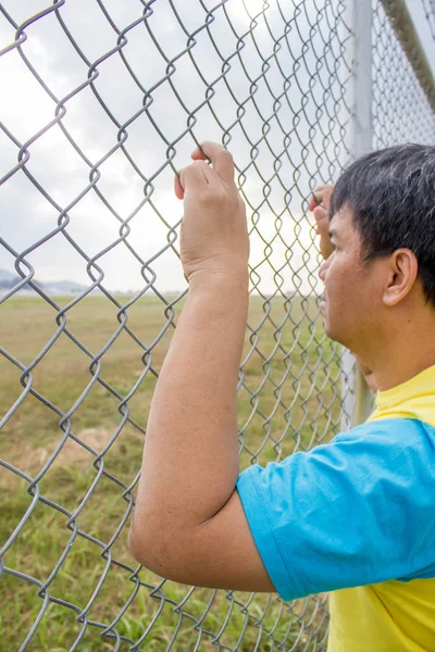 Hand met op ketting link hek — Stockfoto