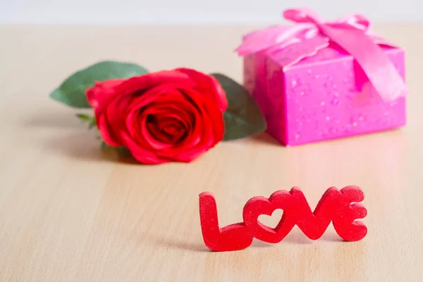 Concept Saint-Valentin avec boîte cadeau, lettres "amour" et ro rouge — Photo