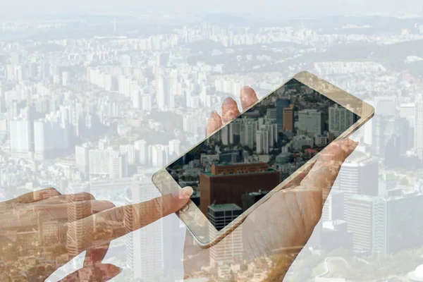 Double exposure of mobile phone and city building — Stock Photo, Image
