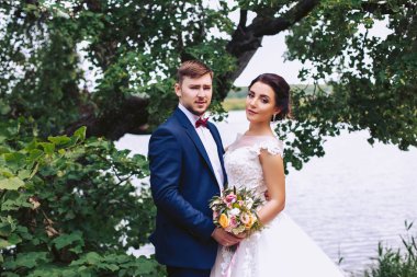 Nehir kıyısında ellerde tarafından gelin damat tutar