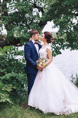 Gelin damat ağaçların altında Nehri kıyısında hugs