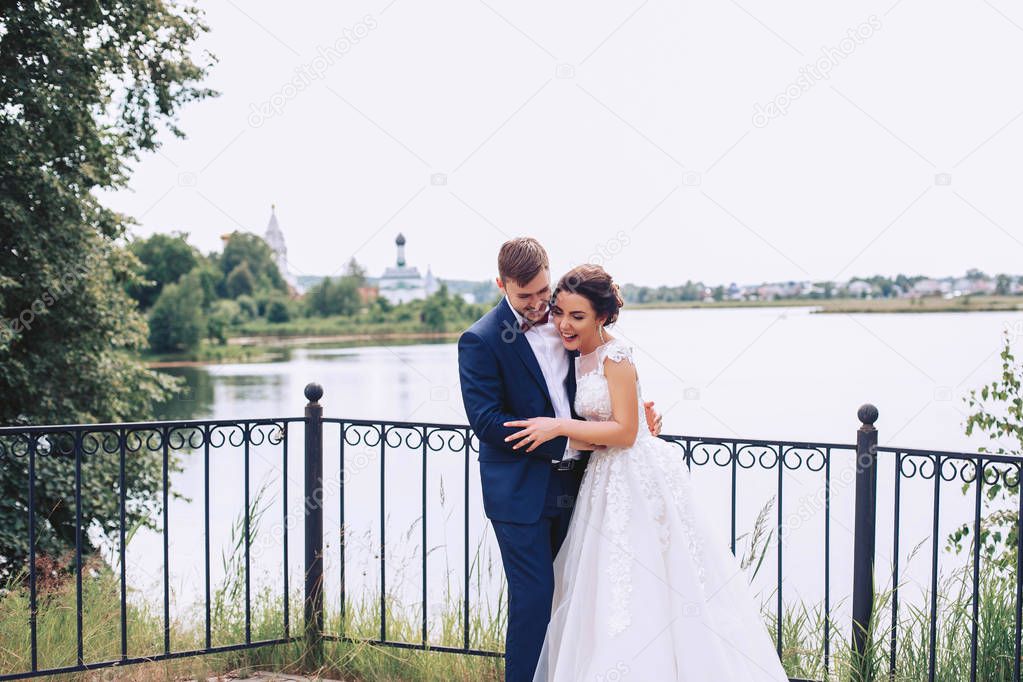 The bride and groom are having fun on the river bank