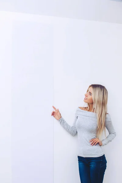 Ein Mädchen Pullover Und Jeans Auf Weißem Hintergrund Zeigt Mit — Stockfoto