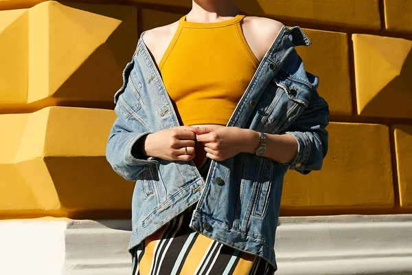 青デニム ジャケットと黄色黄色織り目加工の壁上の裸の肩を持つ女性 ストリート スタイル — ストック写真