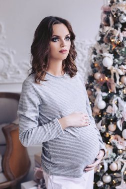 Oldukça hamile esmer göbek tutar. İç güzel ışıkları ile Noel ağacı ile süslüdür.