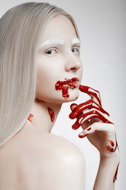 Sarışın beyaz kaşları ile dönüm başı görünüyor. Kanlı el ve yüz ile kız