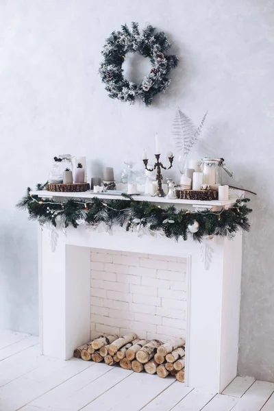 Christmas. White decorative fireplace decorated for Christmas. Wreath over the fireplace