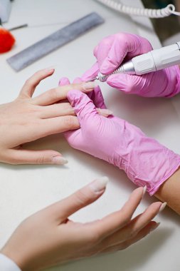 Güzellik salonunda bir manikürcü müşteriler çivi parlatır.