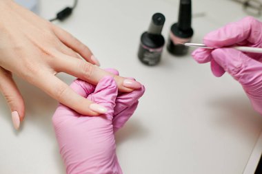 Manikürcü iş başında. Tırnak cilası uygulamak