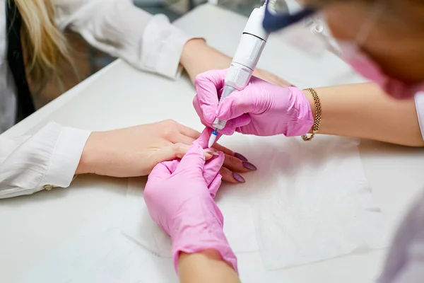 Manicurist polishes the girl\'s nails in the beauty salon