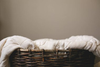 Hasır sepet ile gri arka plan üzerine güzel bir beyaz örme kumaş