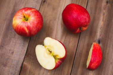 Büyük sulu kırmızı elma ve koyu ahşap bir masa üzerinde onların adet