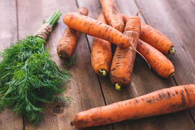Lezzetli, taze havuç ve dereotu doğal ahşap bir masaya. Sağlıklı beslenme