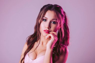 Pembe-mor arka plan üzerinde göz alıcı bir kadının dudakları için elini koyar