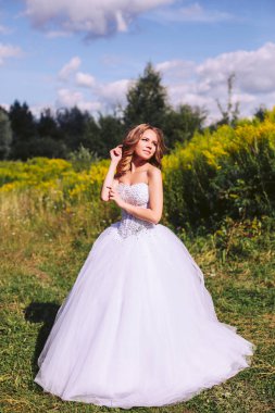 Bir yaz günü parkta yürüyüş beyaz elbiseli Genç gelin