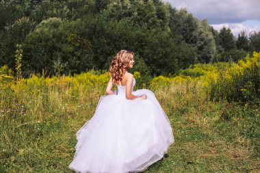 Beyaz bir elbise sevimli gelin açık havada yürüyüş