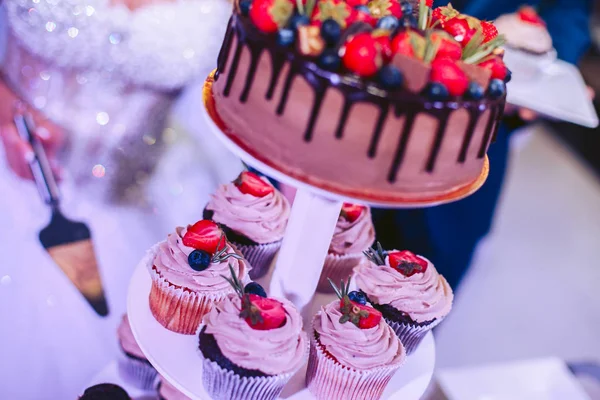 Chocolate wedding cake and cakes on a tray