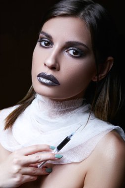 Yanan bir esmer zehirli şırıngayla elinde tutar. Beyaz yarı saydam boyun bandaj.