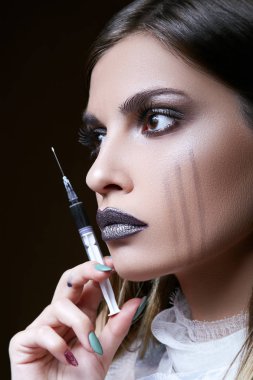 Yüzüne sıvı bir şırınga tutarak siyah gözlü güzel bir esmer portresi