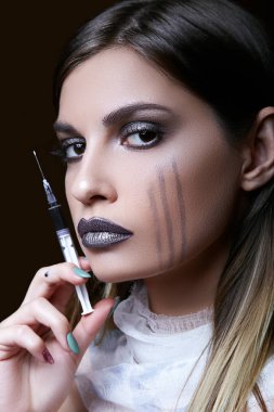 Genç kız onun elinde bir şırınga. Cadılar Bayramı kutlama kavramı.