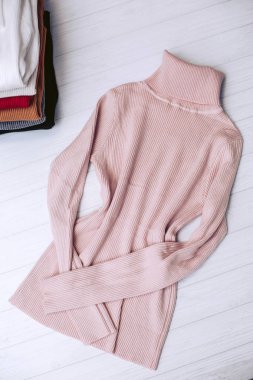 Bir giyim mağazası Beyaz ahşap zemin üzerinde pembe renkte şık Bayan örgü elbise modelleri.