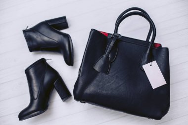 Sonbahar kadınlar boots hakiki deri siyah renk ve Beyaz ahşap zemin üzerinde yalan şık bayan çanta.