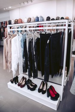 Raflar lüks kadın takım elbise ve ayakkabı ile bir giyim mağazası.