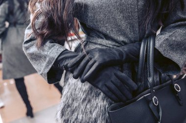 Gri paltolu kızın depodaki lüks uzun siyah eldiven giy.