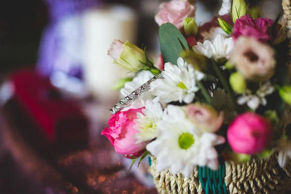在美丽的花朵和装饰的背景下的结婚戒指 — 图库照片
