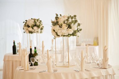 Yemek masaları düğün töreni sırasında beyaz masa örtüsü ve cam vazo içinde Çiçek demetleri ile dekore edilmiştir.