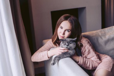 Elbise şirin kız koltukta oturan kedi okşadı