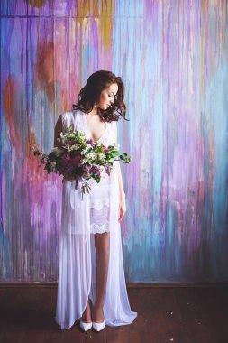 Büyük bir buket çiçek ve stüdyoda poz Beyaz gömlekli gelinle