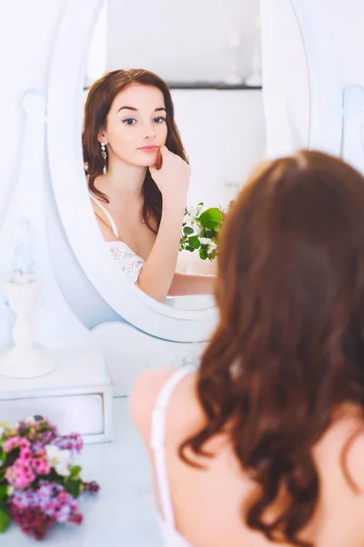 The bride looks in the mirror before the wedding. Wedding preparations