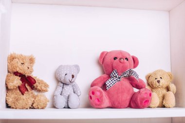 Çocukların oyuncakları ile beyaz dolap raf. Çok renkli ayılar