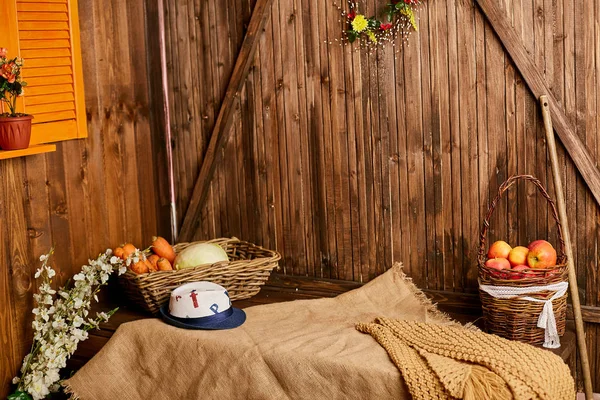Uma mesa com cestas de vime com legumes e frutas em uma casa de madeira — Fotografia de Stock