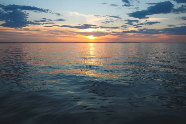 Deniz on Sunset. Güneş bulutların arkasından parlıyor. SM