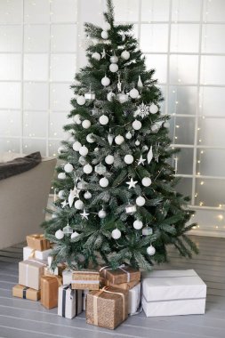 Beyaz toplar ve yeni yıl hediye ile şık Noel ağacı