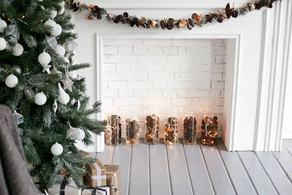 Χριστούγεννα εσωτερικό με ένα χριστουγεννιάτικο δέντρο διακοσμημένο με λευκές μπάλες και λευκές διακοσμητικό τζάκι. — Φωτογραφία Αρχείου
