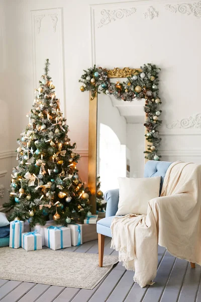Schöner Weihnachtsbaum mit Spielzeug in modernem Interieur. Weihnachtsgeschenke unter dem Baum — Stockfoto