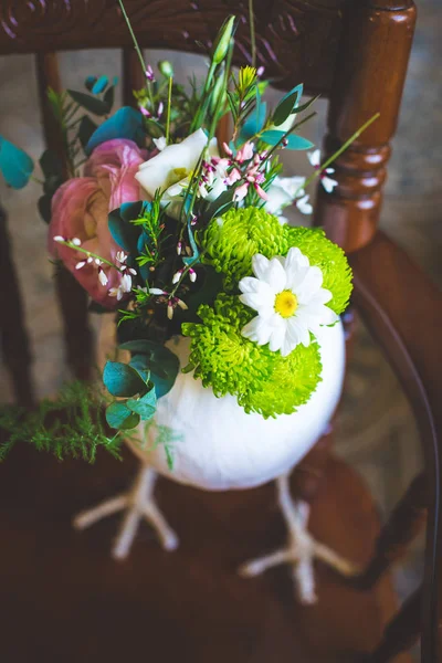 Decorative Easter egg with natural colors on a classic brown stool