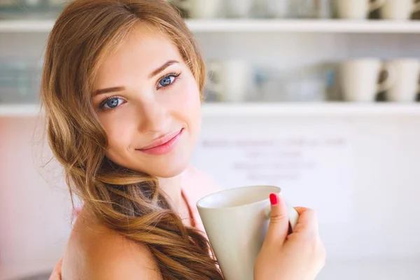 台所で朝早くに手にマグカップと美しい若いヨーロッパの女の子 — ストック写真