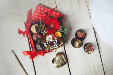 Şekerlemeler ve bir buket çiçek ahşap tabl üzerinde