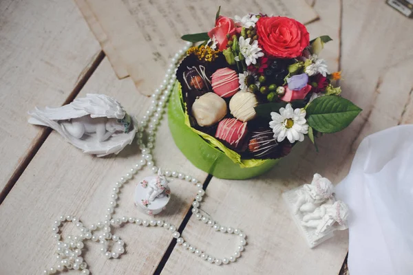 사탕 하 고 패키지에 아름 다운 꽃의 꽃다발. 성 발렌타인의 날에 대 한 나무 테이블에 천사가 형태의 인형 — 스톡 사진
