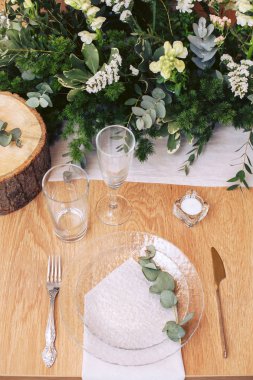 Ahşap bir dekor, çiçek ve taze yeşillik bir buket ile güzel tatil masası.