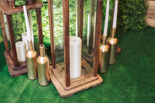 美丽的木制烛台中的白色大蜡烛。背景是天然的绿色。婚礼装饰. — 图库照片