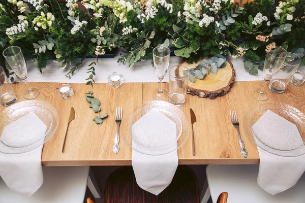 Une table magnifiquement servie au festival est décorée avec du bois naturel et de la verdure fraîche . — Photo
